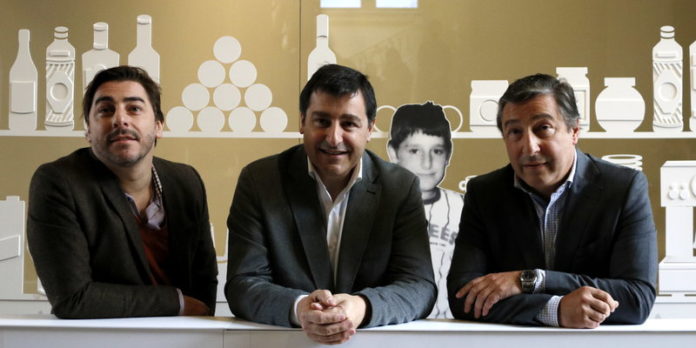 Els tres germans Roca recolzats a la barra d'una recreació del bar familiar, a l'exposició que els hi dedica el Palau Robert, aquest dilluns 21 de novembre (HORITZONTAL)