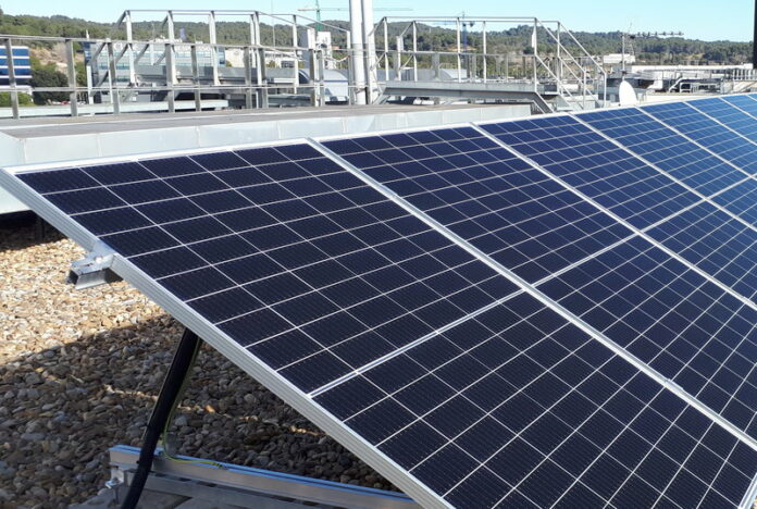 BancSabadell. Imatge del sostre de l'edifici amb plaques solars i façana de l'edifici.